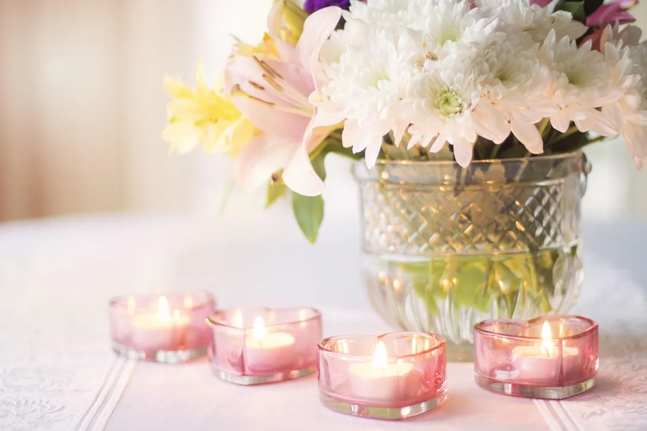 Centre de table bas en fleurs fraîches sur une table ronde de réception, laissant le champ de vision dégagé entre les convives